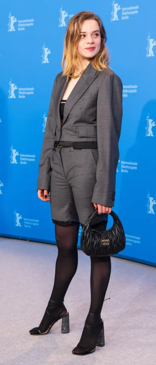 Luna Wedler at the Berlinale 2023 in an oversized grey blazer and shorts with black tights and sparkly heels